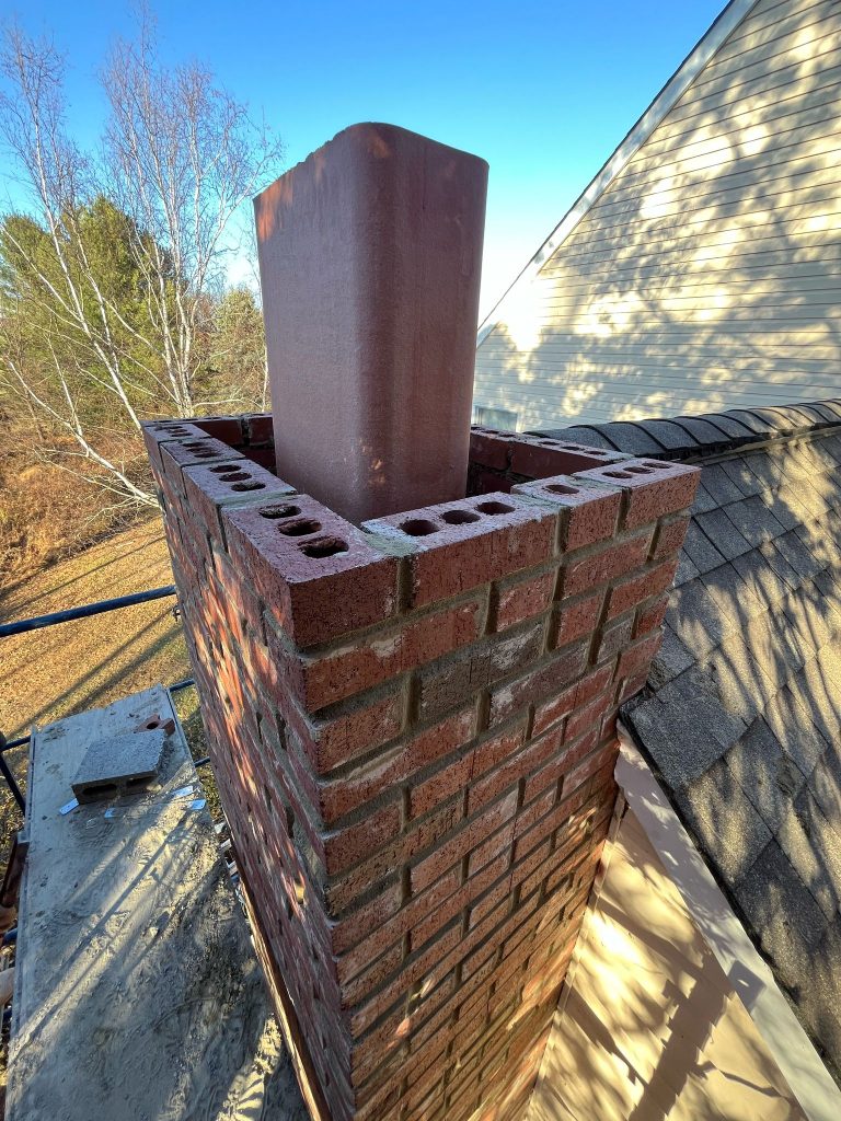 WhatsApp Image 2025 04 07 at 9.45.01 AM 2 If your chimney is leaking, the problem is almost never the chimney itself. It is the flashing — the metal that seals the joint where the chimney meets the roof. When flashing is installed correctly, it handles decades of rain, snow, and freeze-thaw without a single drip into the house. When it is installed with caulk instead of the right sequence of metal pieces, it fails in a few years and the stains start showing up on the ceiling below.